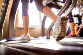 A woman running on a treadmill in a gym